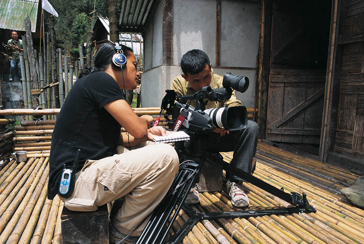 moji-riba-teaching-video-skills-to-tribal-person Riba teaches Hage Komo the basic camera skills that will allow the young Apatani to film an interview with his father and an animist priest, thus recording his tribe's oral history (Photo courtesy Rolex Awards)