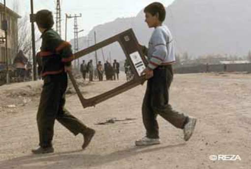 Kids carrying TV frame - photo by Reza Deghati