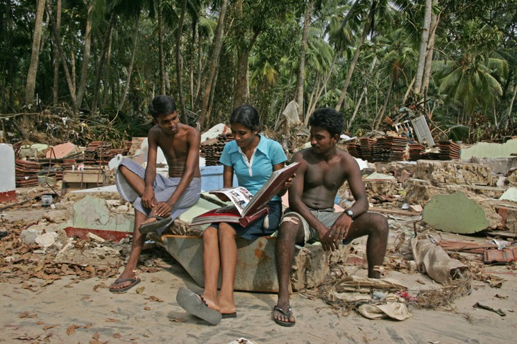 Tsunami survivors look at an lbum of family photos - Telwatte, Sri Lanka - photo by Shahidul Alam