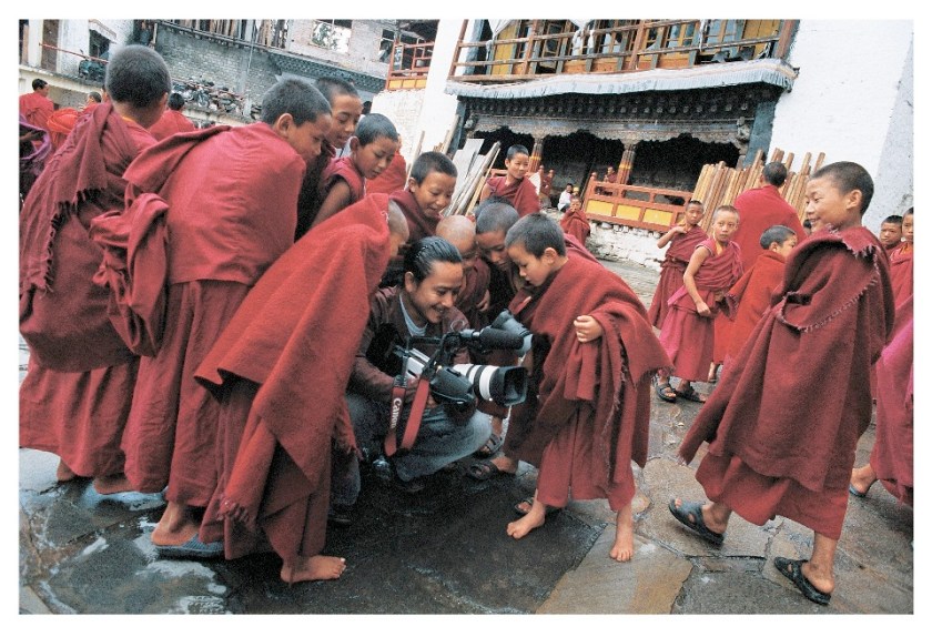 Surrounded by young monks, Moji Riba films rituals celebrating Buddha's birth at Galden Namgyal Lhatse monastery. Tawang, Arunachal Pradesh, India, 2008 (Photo courtesy Rolex Awards)