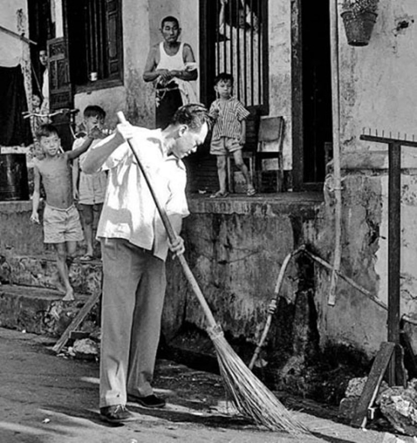 Lee is seen sweeping the streets during a mass clean-up campaign in Singapore, 1959