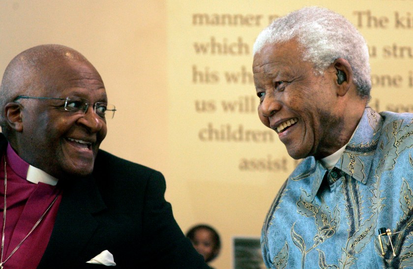 Former South African President Nelson Mandela, right, reacts with Archbishop Desmond Tutu, left, during the launch of a Walter and Albertina Sisulu exhibition, called, 'Parenting a Nation', at the Nelson Mandela Foundation in Johannesburg, South Africa, on 12 March 2008 (AP Photo/Themba Hadebe)