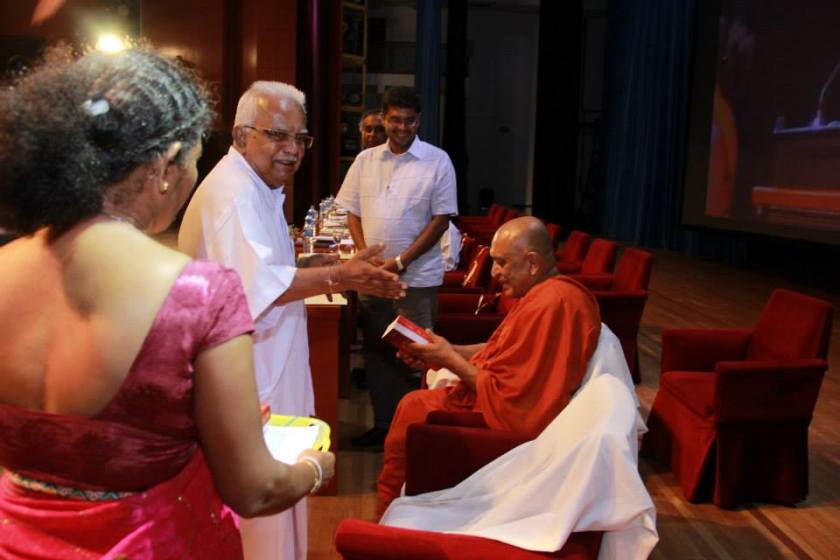 Sarvodaya leader Dr A T Ariyaratne presenting his autobiography to Ven Sobitha at BMICH on 4 Aug 2014 (Sarvodaya photo)